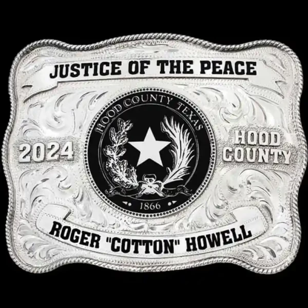 "Justice of the Peace: Upholding fairness, one community at a time. Our Brazos Bend Belt Buckle, crafted from German Silver, features a hand-engraved design with a classic rope edge. Two banners display hand-painted enamel text on the top and bottom,